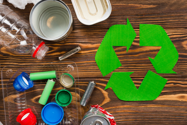 recycle-logo-and-various-recyclable-garbage-on-wooden-desk-1